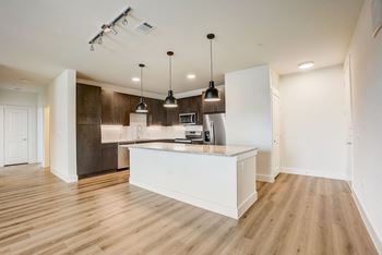 A kitchen with a white island and pendant lights. at Aurora Watson Branch, Mansfield